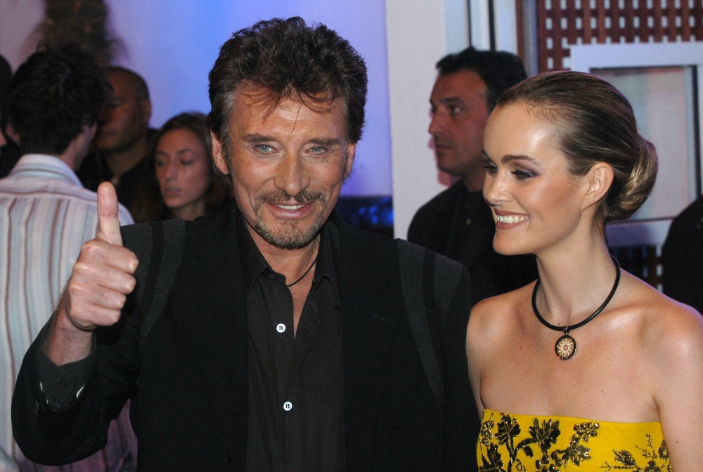 (FILES) In this file photo taken on October 02, 2003 French rock singer Johnny Hallyday (L) poses with his wife Laetitia Boudou.  AFP / JEAN AYISSI
