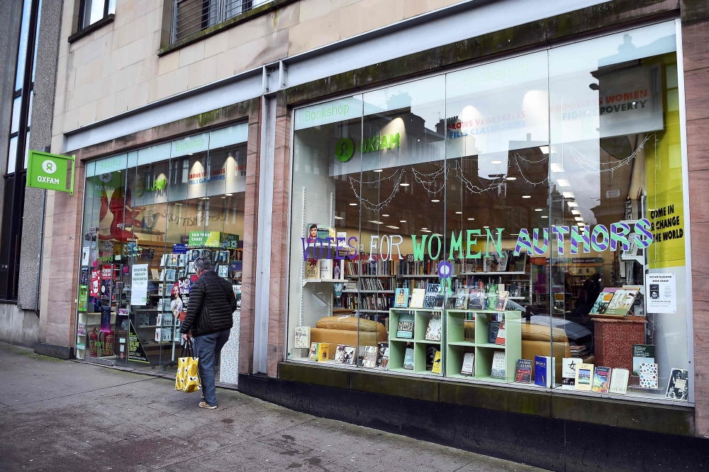 A man walks past the front of an Oxfam bookshop in Glasgow on February 10, 2018. AFP / Andy Buchanan
