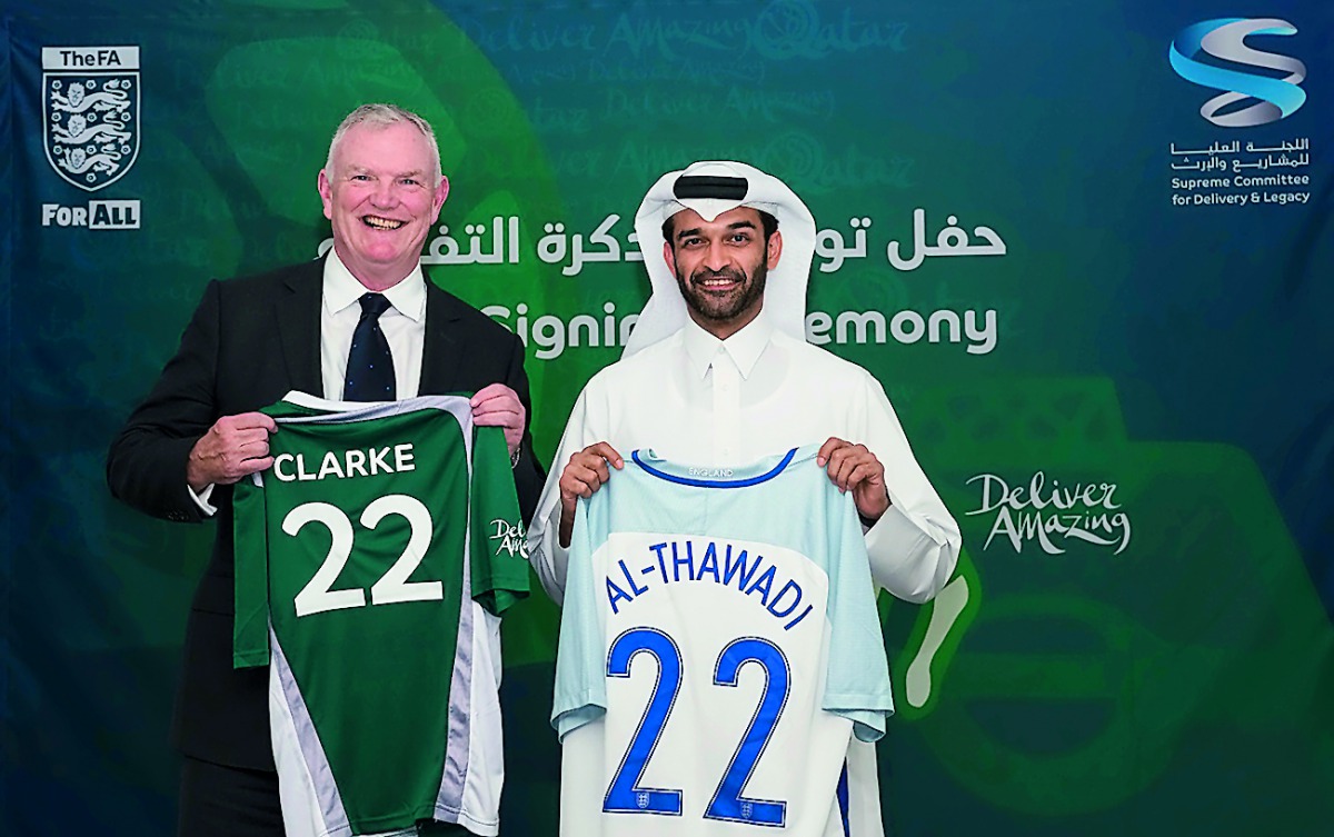 English Football Association Chairman Greg Clarke and Supreme Committee for Delivery & Legacy (SC) Secretary General H E Hassan Al Thawadi hold football jerseys.
