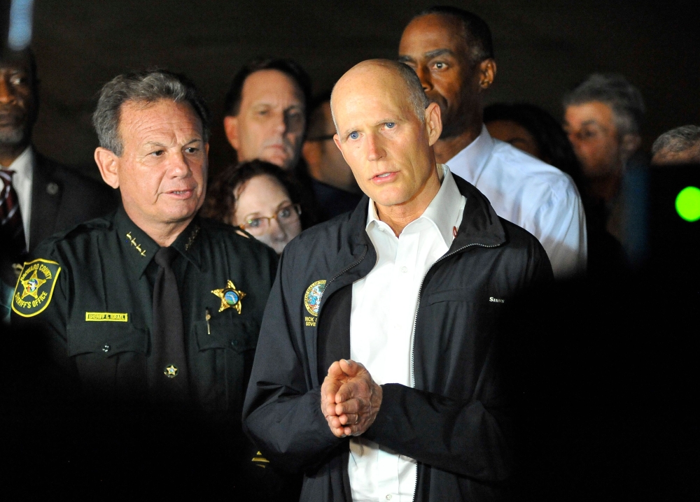 Florida Governor Rick Scott speaks to the media as he visits Marjory Stoneman Douglas High School following a shooting that killed 17 people on February 14, 2018 in Parkland, Florida. / AFP / Gaston De Cardenas
 