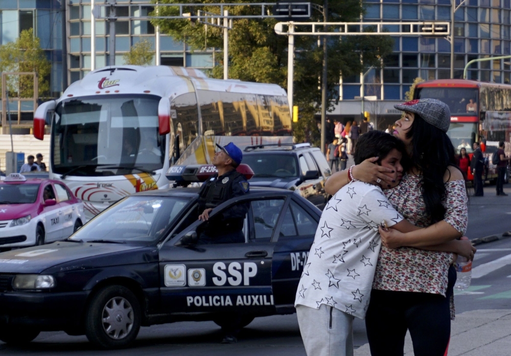 A woman embraces a boy as a powerful earthquake rocks Mexico City on February 16, 2018. AFP / Yuri CORTEZ