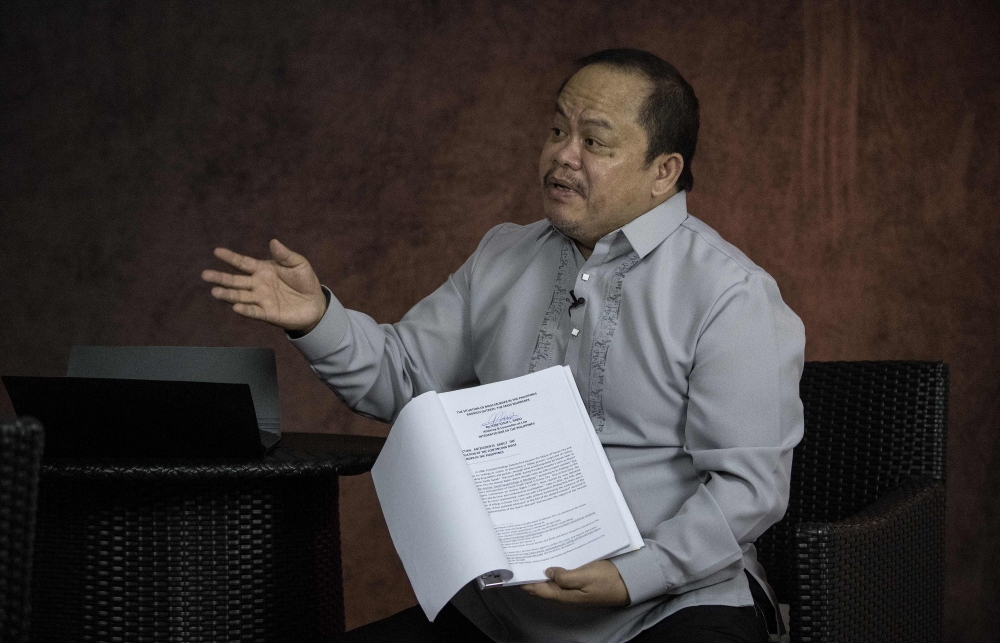 This photo taken on February 16, 2018 shows lawyer Jude Sabio gesturing as he shows the communication he submitted to the International Criminal Court against Philippine President Rodrigo Duterte, during an interview in Manila. AFP / NOEL CELIS
