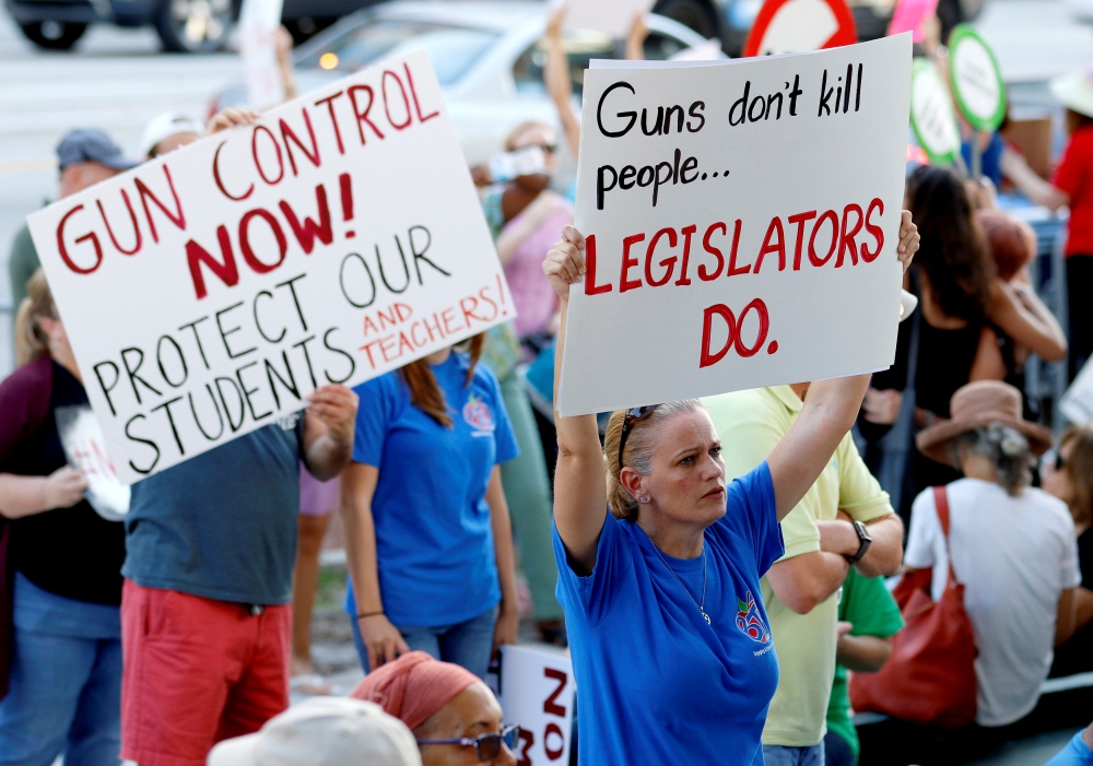 Stefanie Hartman of Coconut Creek, Florida, holds a sign during the March for Action on Gun Violence in Broward County in Fort Lauderdale, Florida, US, February 17, 2018. REUTERS/Joe Skipper 