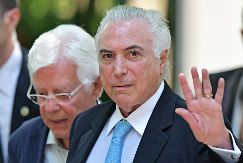 Brazil's President Michel Temer (R) waves as he arrives for a press conference at Guanabara Palace, Rio de Janeiro, on February 17, 2018. AFP
