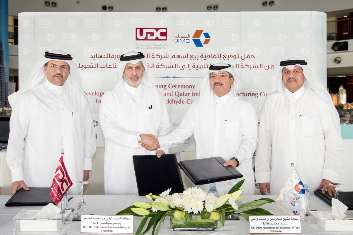 Sheikh AbdulRahman bin Mohamed bin Jabor Al Thani (second right), Chairman of QIMC and Turki bin Mohammed Al Khater (second left), Chairman of UDC shake hands after signing the deal.