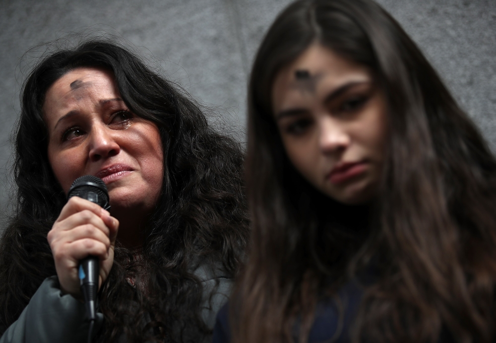 Lourdes Barraza, (L) wife of d etained immigrant Fernando Barraza, fights back tears as she speaks during a Valentine's Day demonstration outside of the San Francisco office of the Immigration and Cutsoms Enforcement (ICE) on February 14, 2018 in San Fran