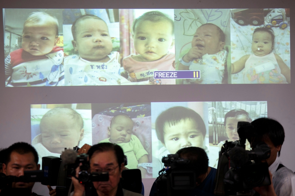 File photo of surrogate babies that Thai police suspect were fathered by a Japanese businessman who has fled from Thailand are shown on a screen during a news conference at the headquarters of the Royal Thai Police in Bangkok August 12, 2014. REUTERS/Athi