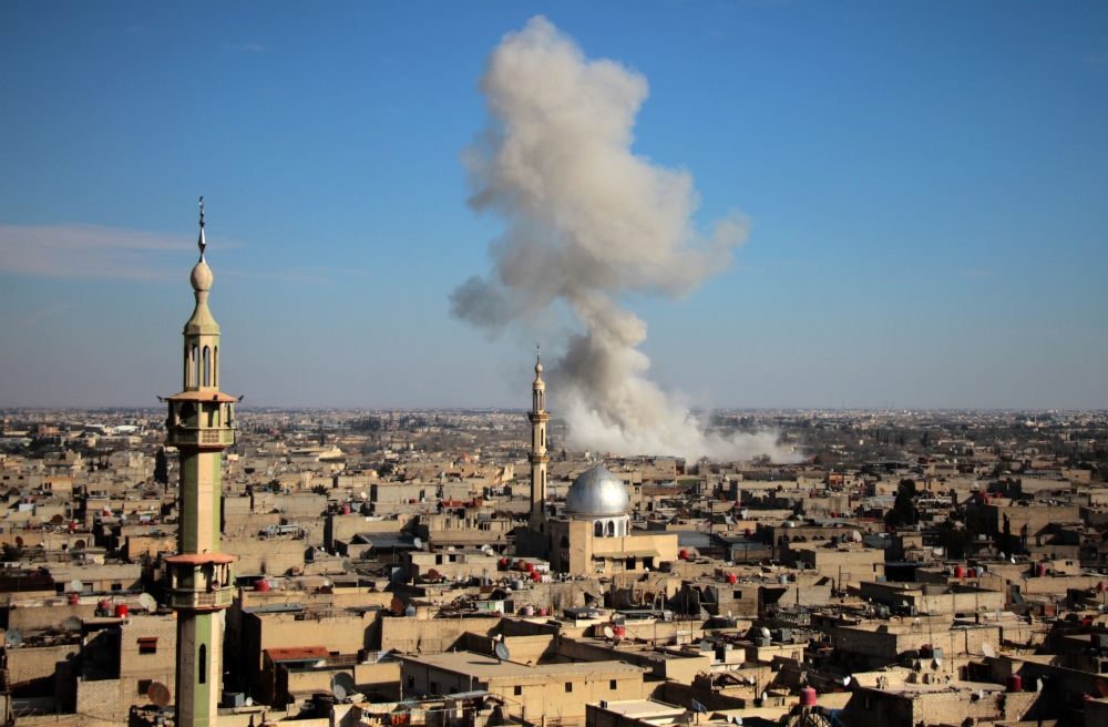 Smoke rises from buildings following bombardment on the village of Mesraba in the rebel-held besieged Eastern Ghouta region on the outskirts of the capital Damascus, on February 19, 2018. AFP / Hamza Al-Ajweh
