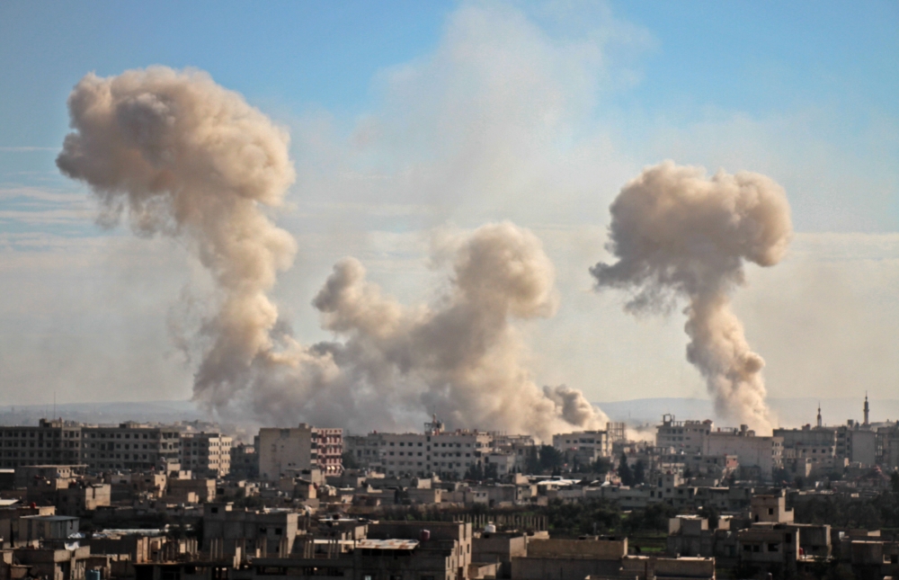 Smoke rises from buildings following bombardment on the village of Mesraba in the rebel-held besieged Eastern Ghouta region on the outskirts of the capital Damascus, on February 19, 2018. AFP / Hamza Al-Ajweh

