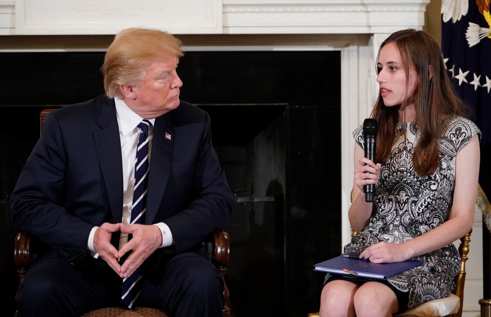 US President Donald Trump listens as Marjory Stoneman Douglas High School Carson Abt speaks during a “listening session” on gun violence with teachers and students in the State Dining Room of the White House on February 21, 2018. AFP / MANDEL NGAN