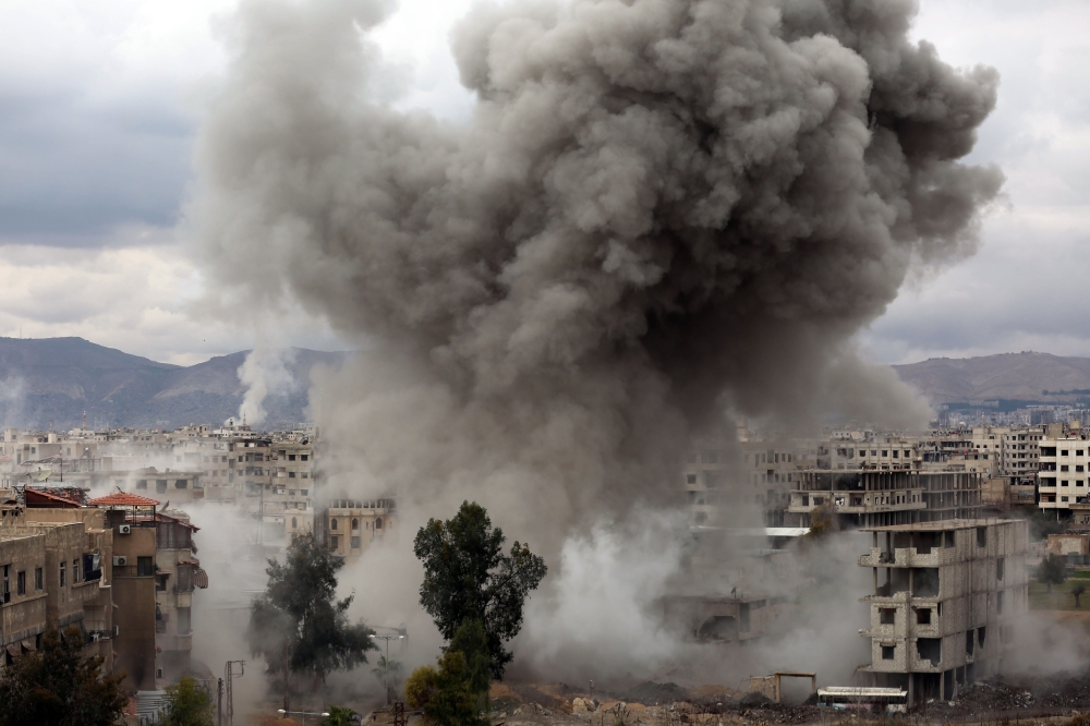 Smoke billows following Syrian government bombardments on Kafr Batna, in the besieged Eastern Ghouta region on the outskirts of the capital Damascus on February 22, 2018. / AFP / AMER ALMOHIBANY 