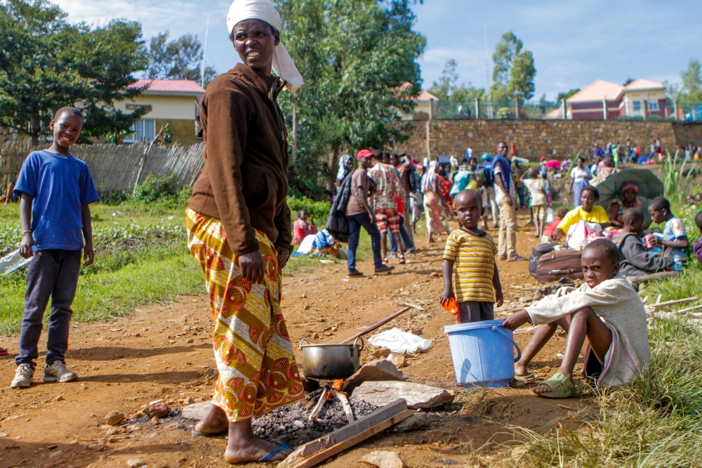 A refugee from the Democratic Republic of Congo is seen with her children as they prepare a meal near the United Nations High Commissioner for Refugees (UNHCR) offices in Kiziba refugee camp in Karongi District, Rwanda February 21, 2018. REUTERS/Jean Bizi
