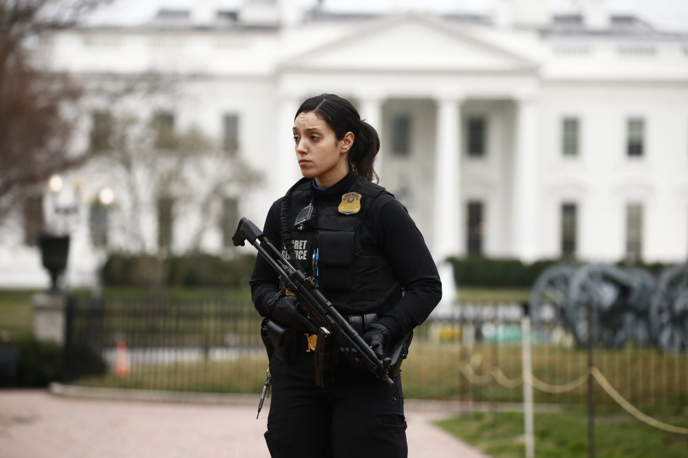 A uniformed US Secret Service officer stands guard after a passenger vehicle struck a security barrier near the White House in Washington, US, February 23, 2018. REUTERS/Jim Bourg