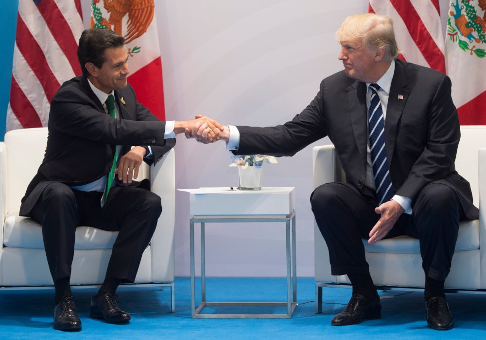 File photo of US President Donald Trump and Mexican President Enrique Pena Nieto shaking hands during a meeting on the sidelines of the G20 Summit in Hamburg, Germany, July 7, 2017.  / AFP / SAUL LOEB
 