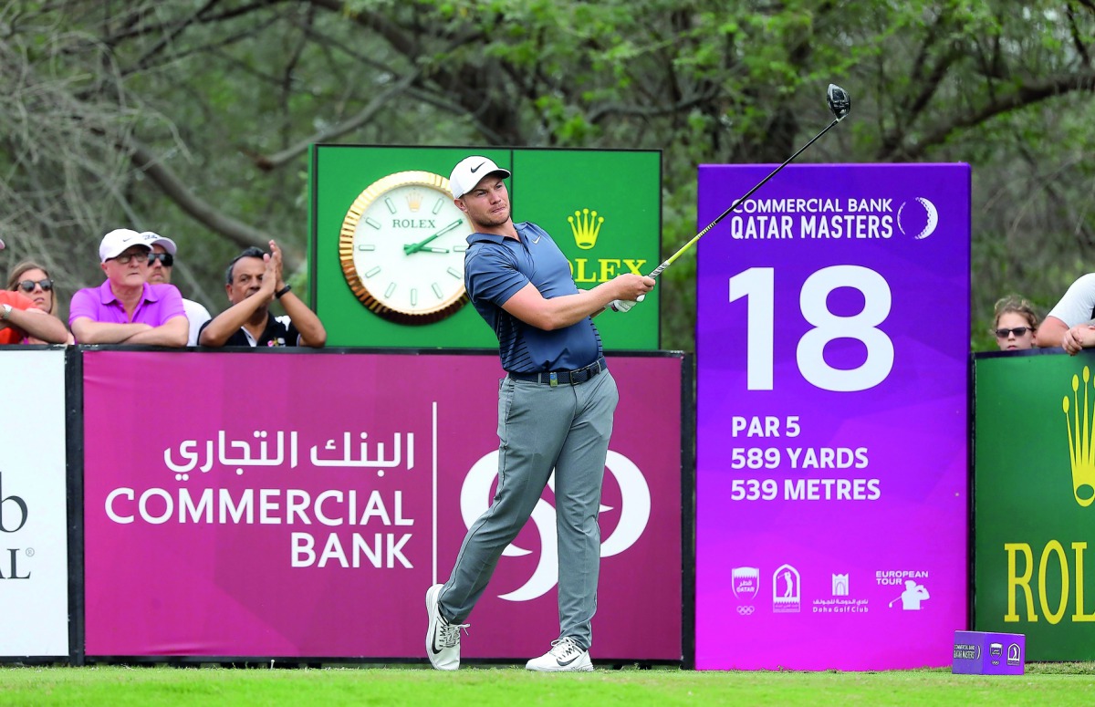 Oliver Fisher of England plays a shot during the third round of the Qatar Masters golf tournament at the Doha Golf Club in Doha, yesterday.