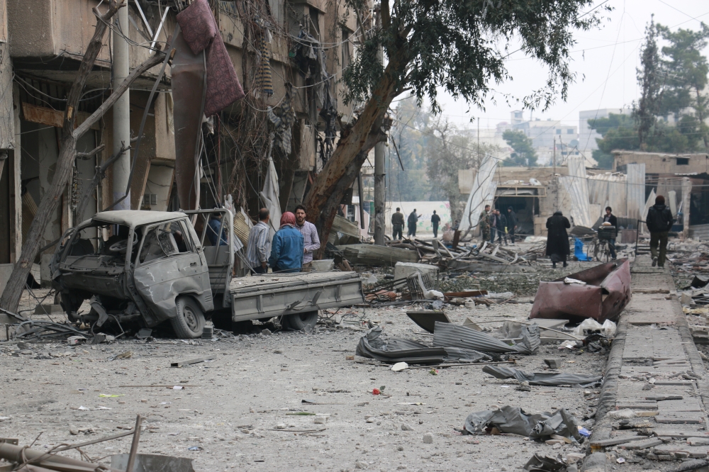 Damaged buildings and a vehicle are seen after Assad regime forces carried out airstrikes over the de-escalation zone in Arbin town of Eastern Ghouta in Damascus, Syria on February 23, 2018. Qusay Noor - Anadolu
