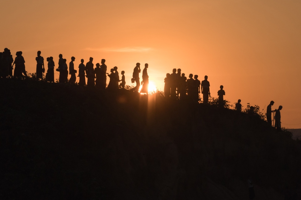 (FILE PHOTO) In this file photo taken on November 26, 2017 Rohingya Muslim refugees walk down a hillside in the Kutupalong refugee camp in Cox's Bazar.  AFP / Ed JONES
