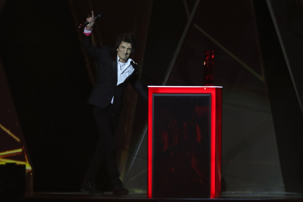Rolling Stones guitarist Ronnie Wood gestures as he walks out to make a presentation during the BRIT Awards 2018 ceremony and live show in London on February 21, 2018. AFP / Daniel Leal-Olivas 