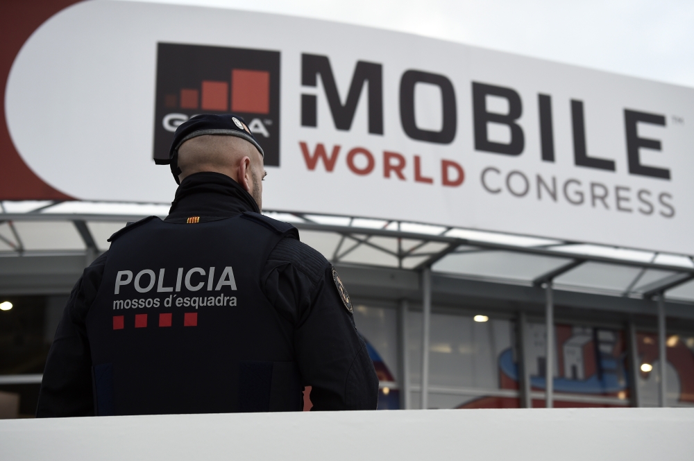 A Catalan regional police officer stands outside the venue of the Mobile World Congress (MWC) on February 26, 2018 in Barcelona. The Mobile World Congress, the world's biggest mobile fair, is held in Barcelona from February 26 to March 1. / AFP / Josep LA