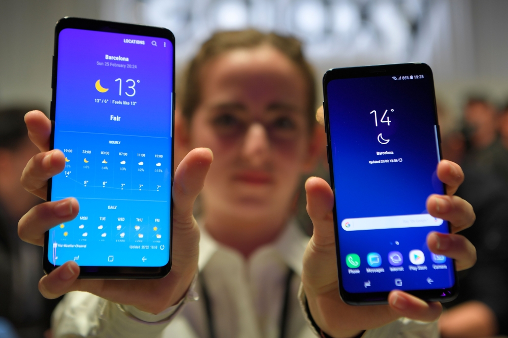 A hostess holds two new Samsung Galaxy S9 mobilephones during the Samsung Galaxy S9 Unpacked event on February 25, 2018 in Barcelona, on the eve of the inauguration of the Mobile World Congress (MWC). (AFP / LLUIS GENE)