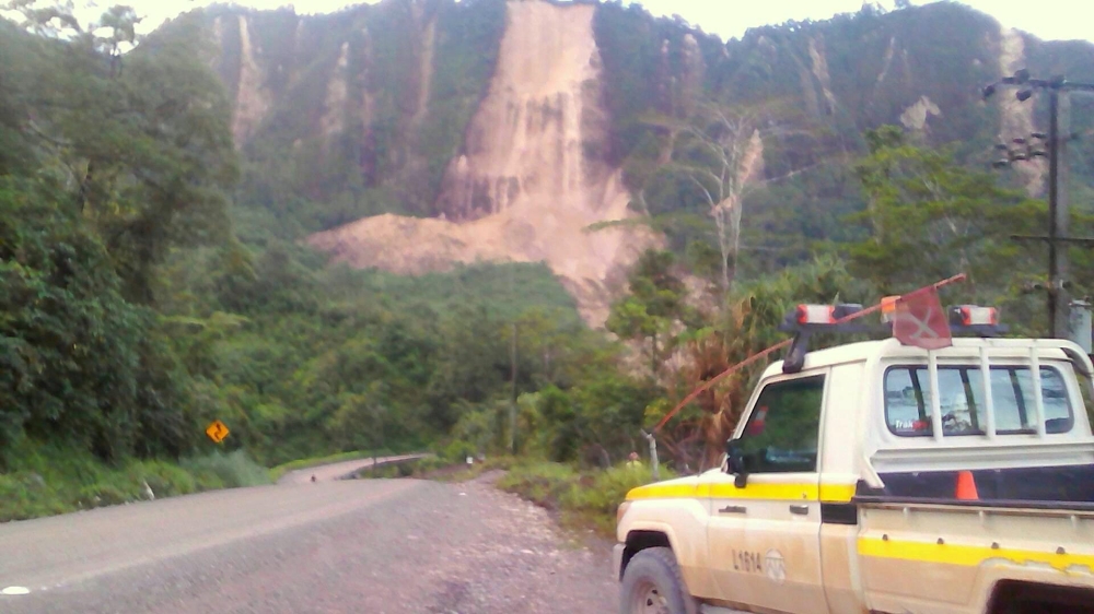A supplied image shows locals inspecting a landslide and damage to a road located near the township of Tabubil after an earthquake that struck Papua New Guinea's Southern Highlands, February 26, 2018. Jerome Kay/Handout via REUTERS
