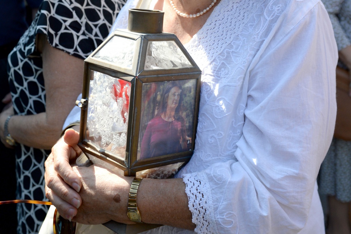 A woman holds a lantern with a picture of murdered journalist Daphne Caruana Galizia outside the law court in Valletta, Malta, on October 17, 2017.  (AFP / Matthew Mirabelli) 