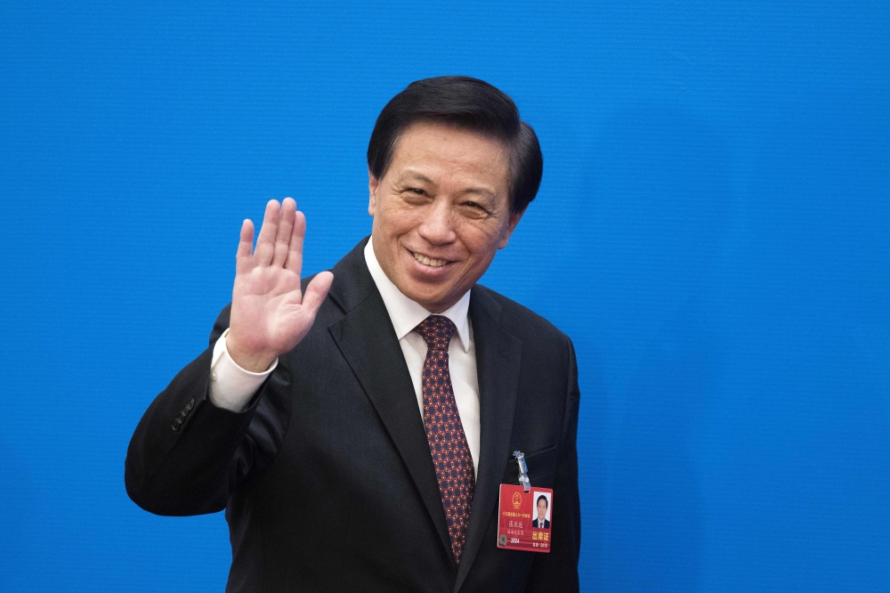 Zhang Yesui, the spokesperson of China's National People's Congress, waves during a press conference at the Great Hall of the People in Beijing on March 4, 2018. AFP / Nicolas Asfouri 