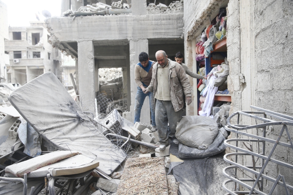 Abu Mohammad Alaya, 50, is helped after getting out from shelter in Douma, Syria February 22, 2018. REUTERS/Bassam Khabieh
