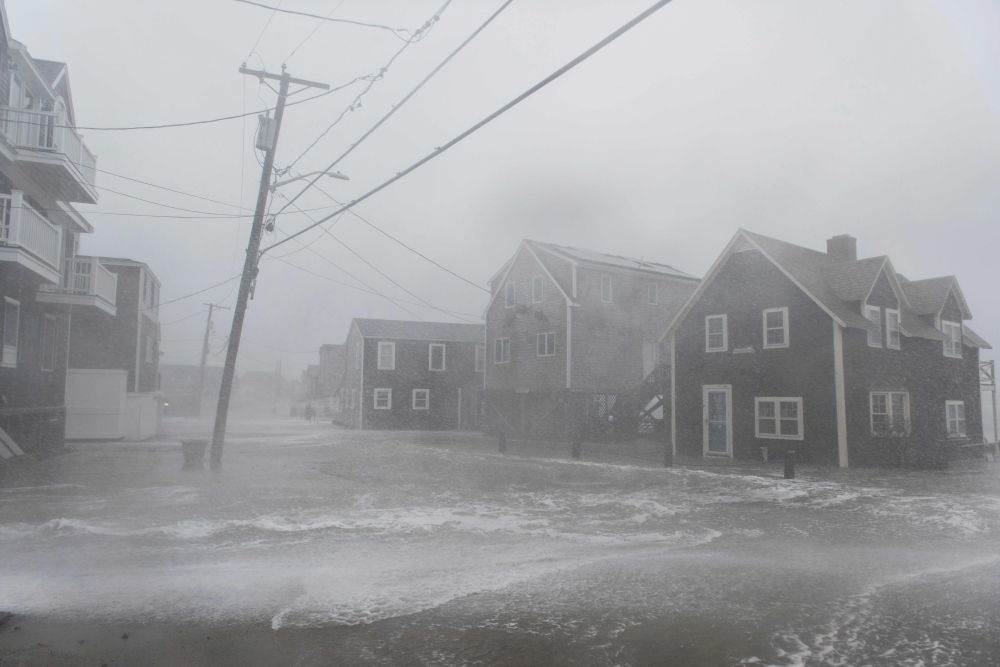 Coastal areas in New England are bracing for the high tide that is scheduled to be at it's highest as waves crash into homes in Scituate, Massachusetts on March 2, 2018.  AFP / RYAN MCBRIDE
