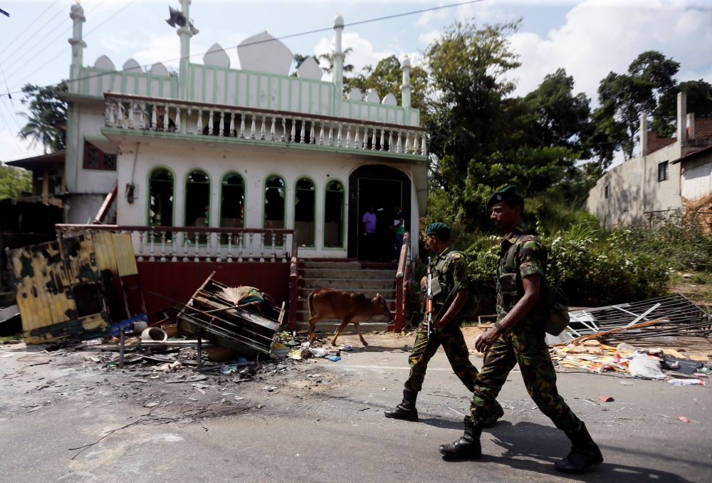 Sri Lanka's Special Task Force soldiers walk past a damaged mosque after a clash between two communities in Digana central district of Kandy, Sri Lanka March 8, 2018. REUTERS/Dinuka Liyanawatte

