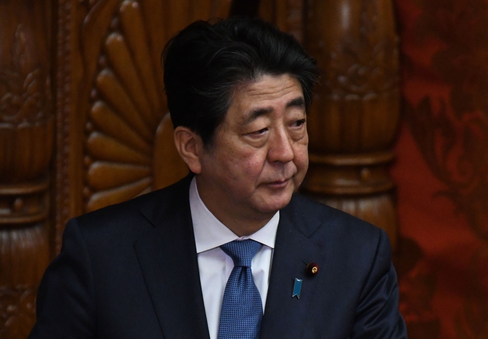 Japanese Prime Minister Shinzo Abe looks at upper house members at parliament in Tokyo on March 9, 2018.  / AFP / Toru YAMANAKA 