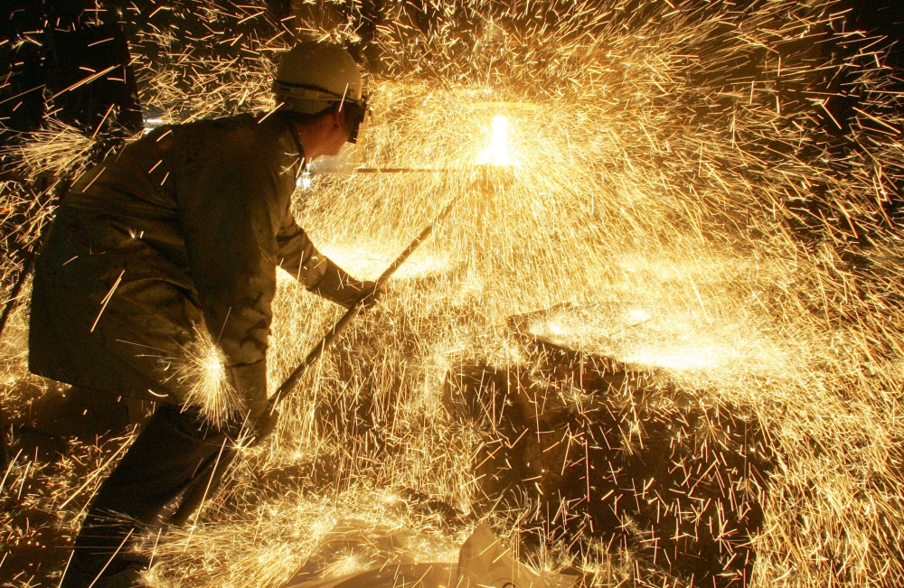 In this file photo taken on April 12, 2006 an iron and steel worker makes a test on a casting at Ascometal factory in Fos-sur-Mer, south-eastern France (AFP / Boris Horvat) 