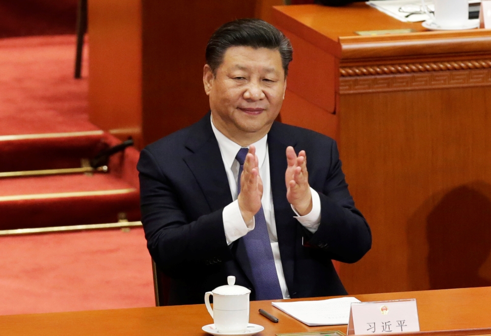Chinese President Xi Jinping applauds after the parliament passed a constitutional amendment lifting presidential term limits, at the third plenary session of the National People's Congress (NPC) at the Great Hall of the People in Beijing, China March 11,
