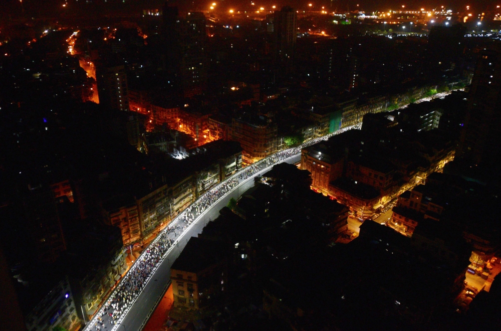 Farmers march along a road early morning in Mumbai on March 12, 2018.  Thousands protested in Mumbai after walking more than a hundred kilometres to demand better crop prices and land rights. The farmers, wearing red caps and carrying red flags, arrived i