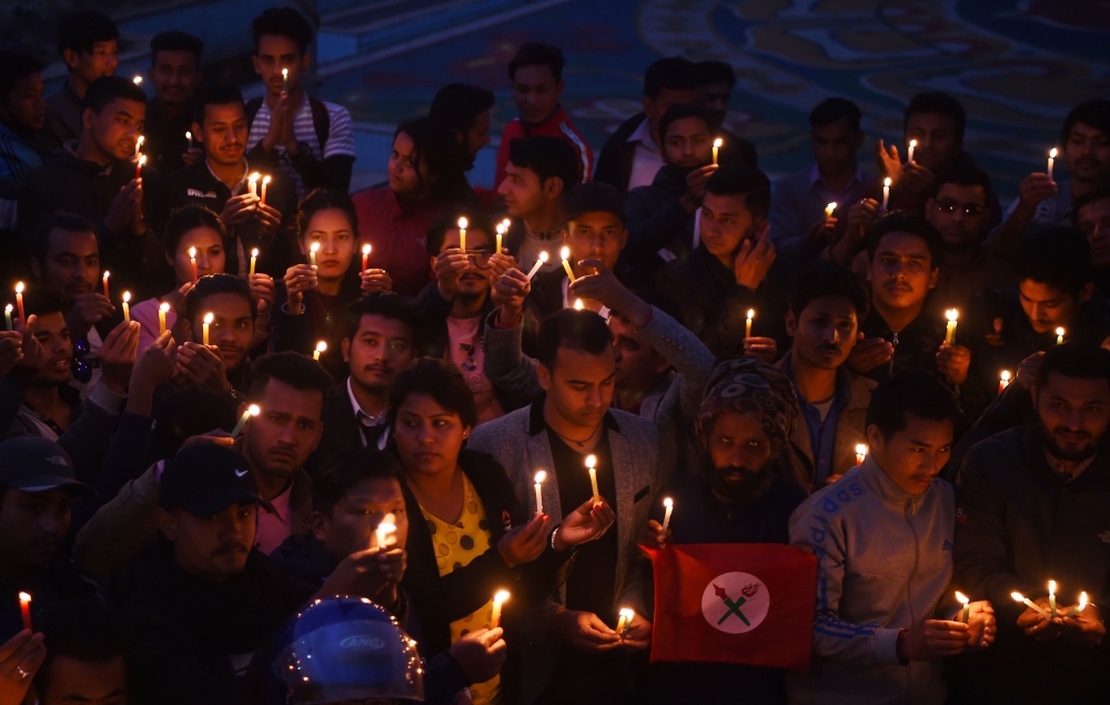 Nepali people take part in a candlelight vigil in honour of the plane crash victims in Kathmandu on March 13, 2018, a day after the deadly crash of a US-Bangla Airlines plane at the international airport. AFP / PRAKASH MATHEMA
