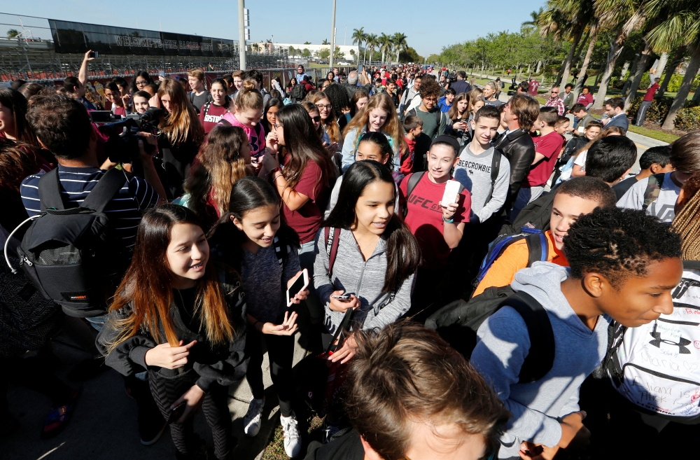 Students march from Westglades Middle School to a nearby park with students from Marjory Stoneman Douglas High School as part of a National School Walkout to honor the 17 students and staff members killed at the school in Parkland, Florida, U.S., March 14