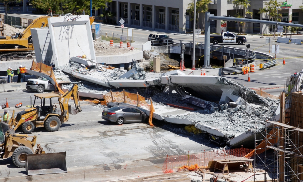 Workers remove debris from a collapsed pedestrian bridge at Florida International University in Miami, Florida, U.S., March 16, 2018. REUTERS/Joe Skipper