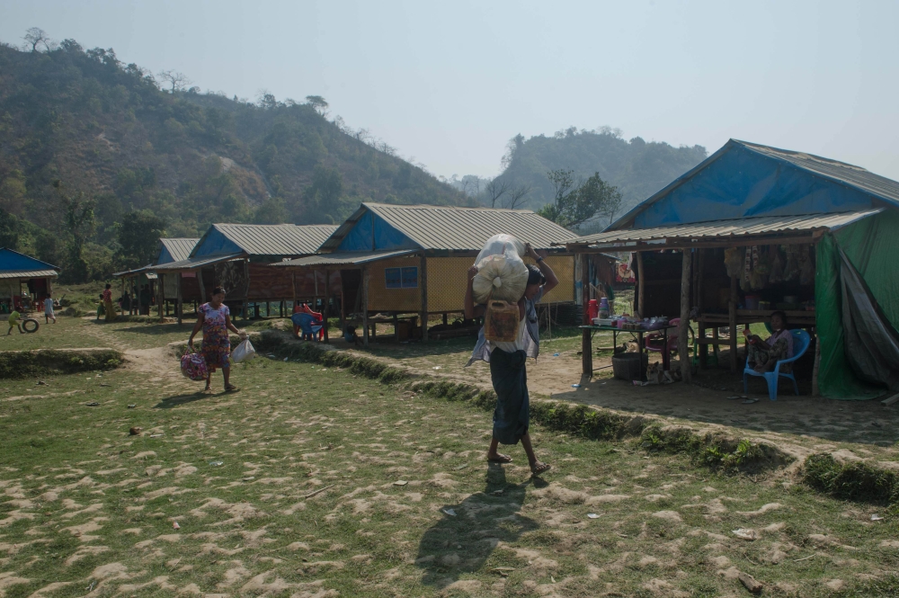 This photo taken on March 8, 2018 shows Rakhine villagers carrying their belongings in Koe Tan Kauk village, Rathedaung township in Myanmar's Rakhine State.  AFP / PHYO HEIN KYAW 
