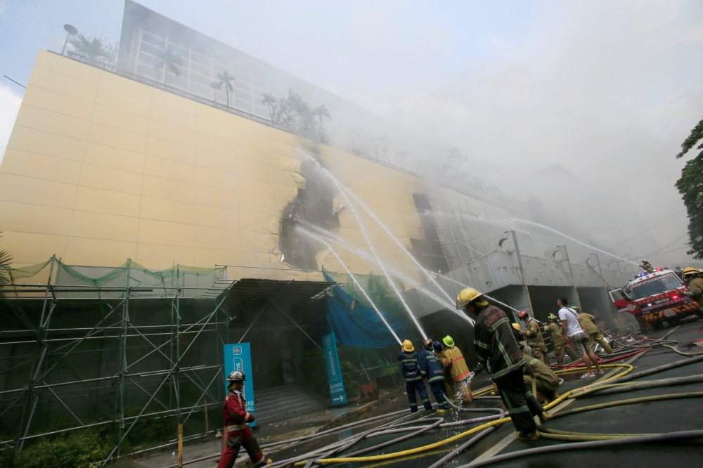 Firefighters douse water after a fire engulfed the Manila Pavilon hotel in Metro Manila, Philippines March 18, 2018. REUTERS/Romeo Ranoco
 