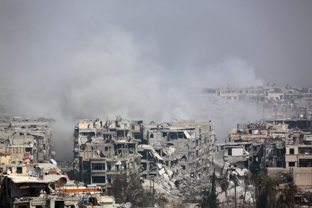 Smoke billows following Syrian government bombardment on the rebel-held besieged town of Harasta, in the Eastern Ghouta region on the outskirts of Damascus on March 12, 2018. AFP 
