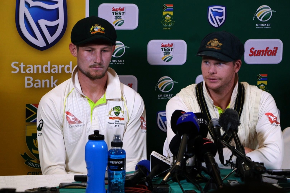 This video grab taken from a footage released by AFP TV shows Australia's captain Steve Smith (R), flanked by teammate Cameron Bancroft, speaking during a press conference in Cape Town, on March 24, 2018 as he admitted to ball-tampering during the third T