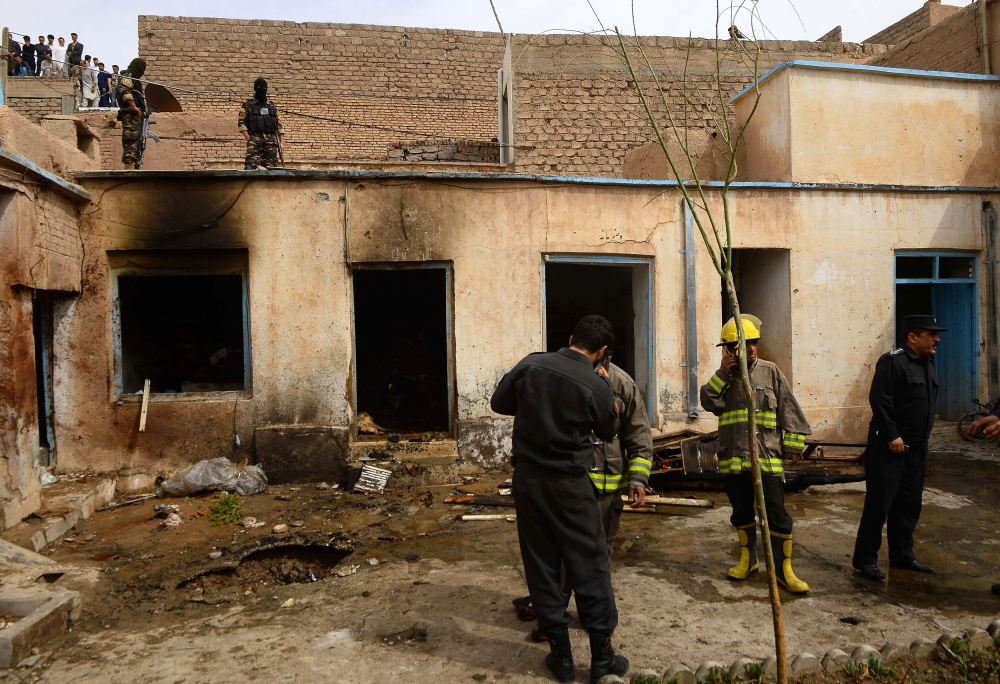 Afghan security personnel inspect the site after two suicide bombers struck a mosque in Herat on March 25, 2018. / AFP / HOSHANG HASHIMI 