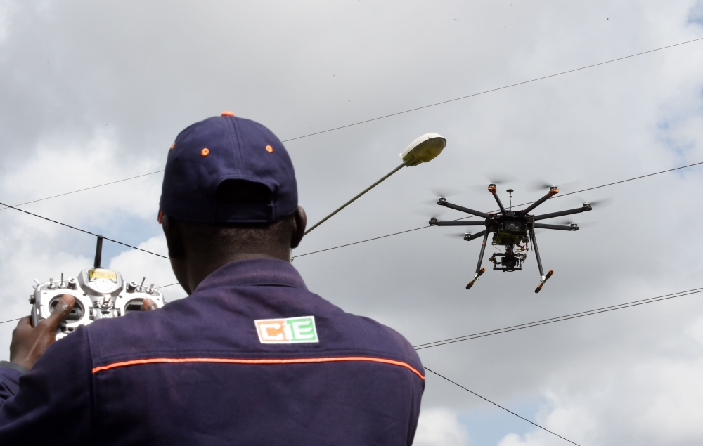 (FILES) In this file photo taken on July 10, 2017 an employee of the Ivorian Electricity company (CIE) pilots a drone that ensures the monitoring of the high voltage electric network at the Centre des Metiers de l'Electricite (Electricity Professional Cen
