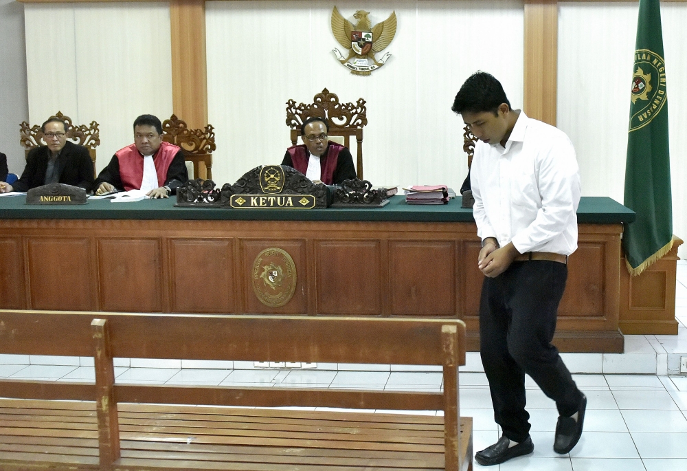 Indonesian defendant I Putu Astawa, 25, walks in a court in Denpasar on March 26, 2018, befor being sentenced to 15 years in jail for stabbing an elderly Japanese couple to death during a botched burglary. AFP / Raka Yoda