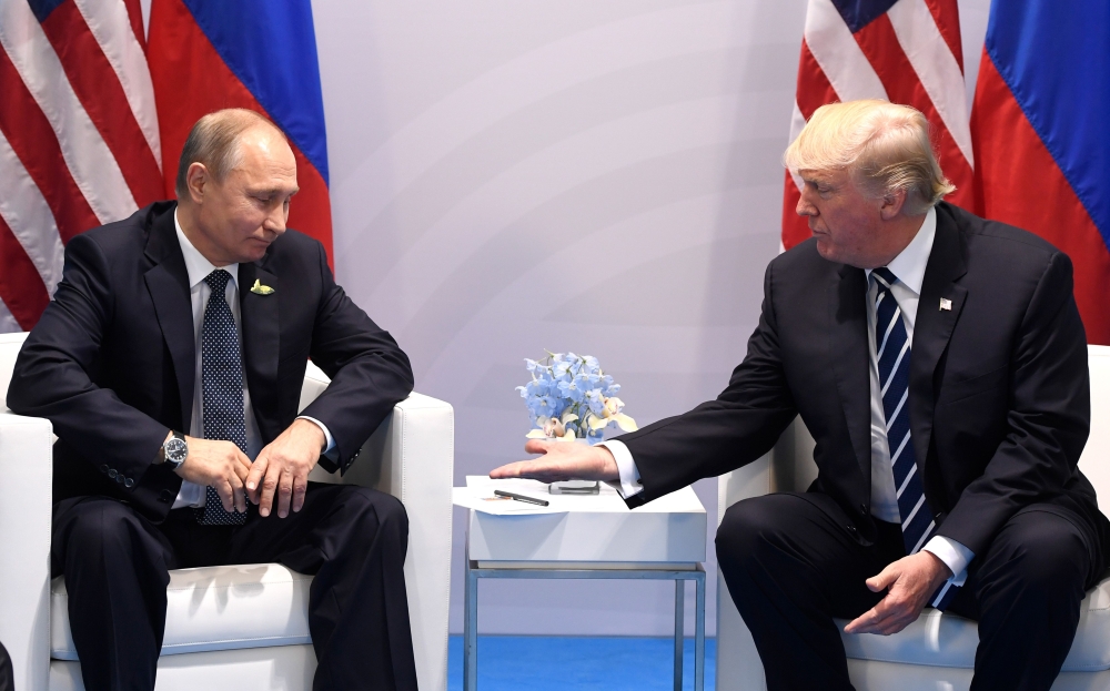 (FILES) In this file photo taken on July 7, 2017 US President Donald Trump and Russia's President Vladimir Putin shake hands during a meeting on the sidelines of the G20 Summit in Hamburg, Germany. AFP / SAUL LOEB