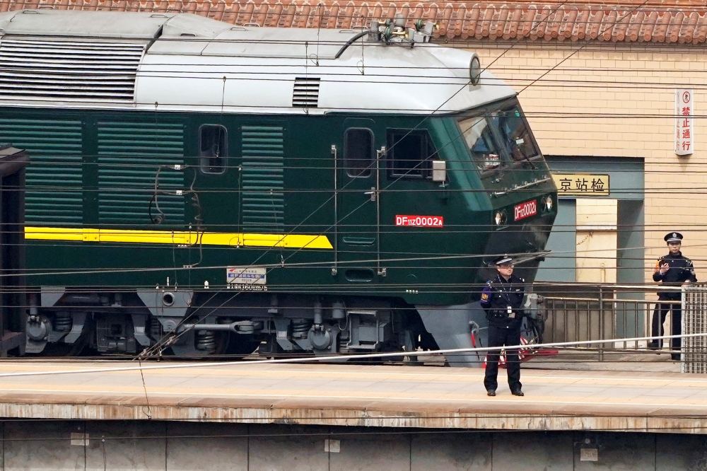 Police officers keep watch next to a train at the Beijing Railway Station in Beijing, China March 27, 2018. REUTERS/Jason Lee