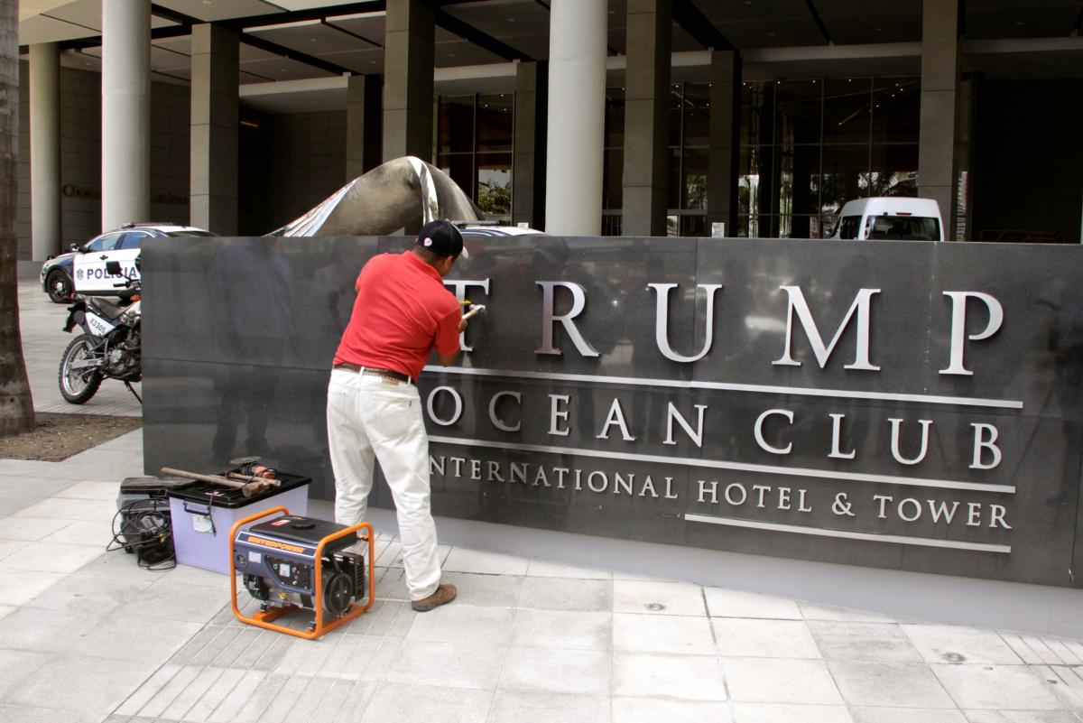 A worker removes the Trump name from the Trump Ocean Club International Hotel and Tower in Panama City, Panama March 5, 2018. Reuters/Carlos Lemos