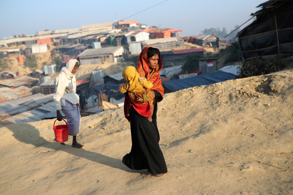 FILE PHOTO: Rohingya refugees walk at Jamtoli camp in the morning in Cox's Bazar, Bangladesh, January 22, 2018. REUTERS/Mohammad Ponir Hossain/File Photo

