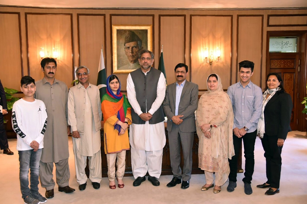 Pakistani Prime Minister Shahid Khaqan Abbasi (C) posing for a photograph with Pakistani activist and Nobel Peace Prize laureate Malala Yousafza (4L) and her family at the Prime Minister Office during her visit to Islamabad. AFP 