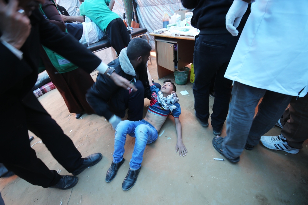 A Palestinian youth suffering from tear gas exposure during clashes with Israeli security forces following a demonstration commemorating Land Day, receives treatment in a medical tent near the border with Israel, east of Khan Yunis, in the southern Gaza S